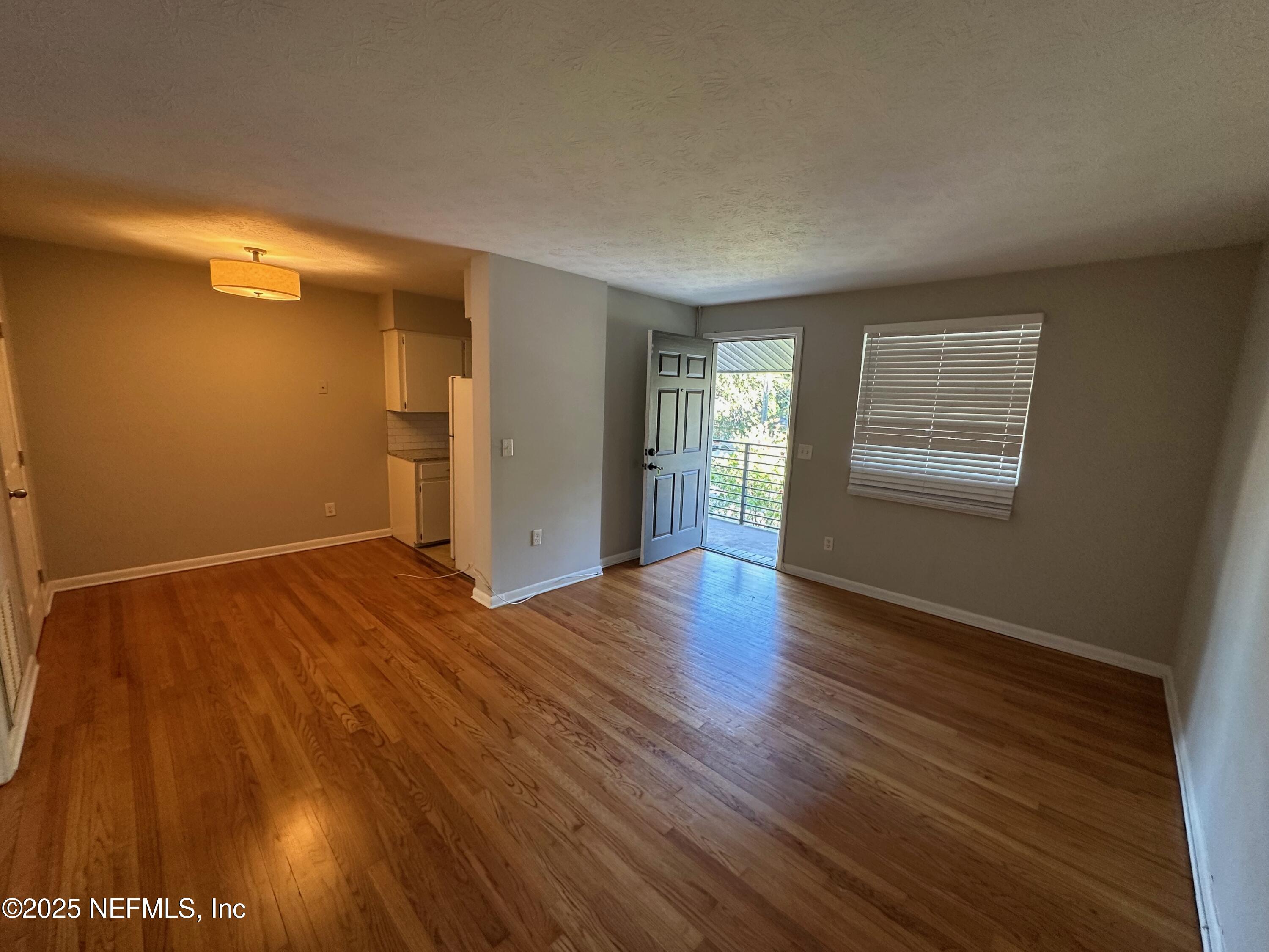 1120 Cedar Street, Unit F Jacksonville, FL 32207 - Photo 6 of 19 a view of an empty room with wooden floor and a window