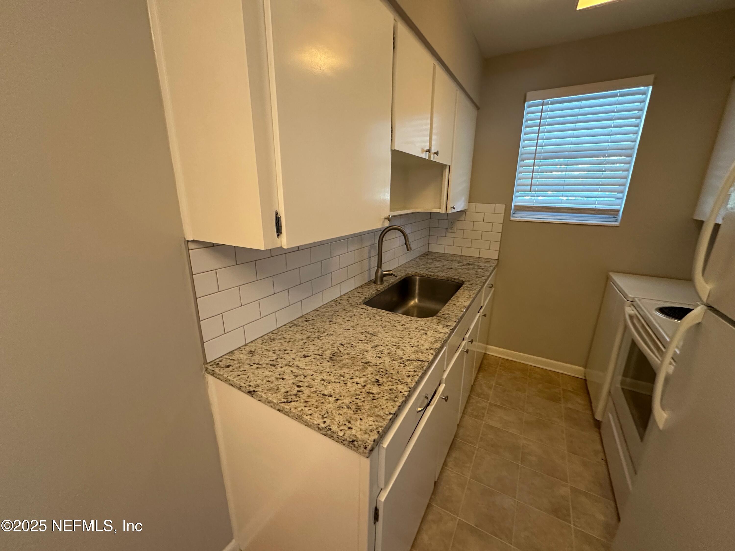 1120 Cedar Street, Unit F Jacksonville, FL 32207 - Photo 8 of 19 a kitchen with a sink stove and mirror