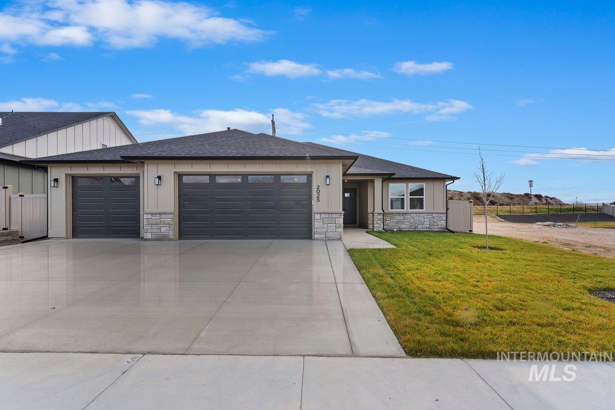 2025 West Bittern Street Nampa, ID 83686 - Photo 2 of 32 View of front facade with stone siding, a garage, and roof with shingles