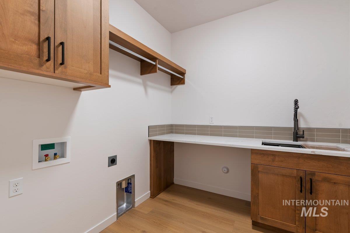 2025 West Bittern Street Nampa, ID 83686 - Photo 27 of 32 Washroom with cabinet space, light wood-style flooring, hookup for a washing machine, and hookup for an electric dryer