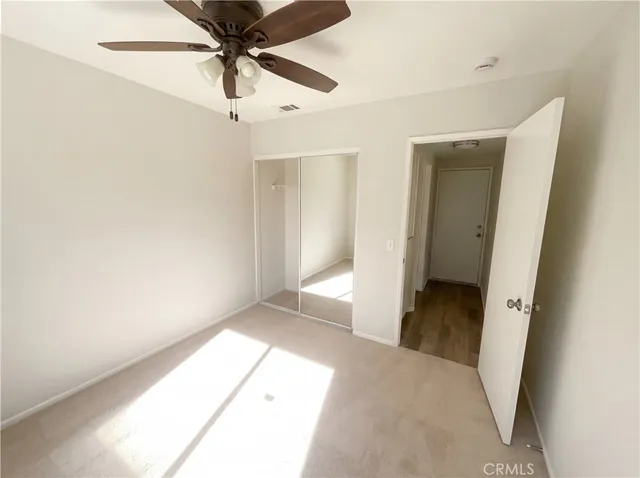 a view of a hallway with a chandelier fan