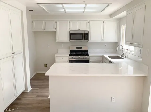 a kitchen with granite countertop a sink and a stove top oven