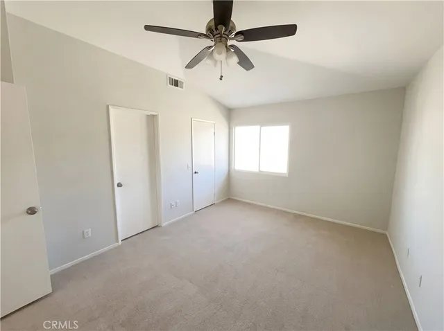 an empty room with windows and fan