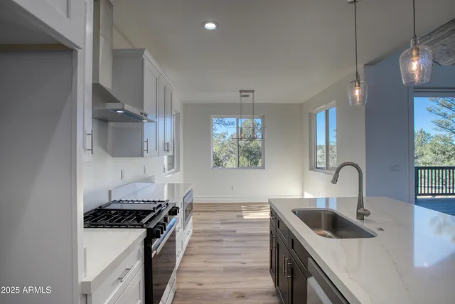 a kitchen with granite countertop a sink stainless steel appliances and cabinets