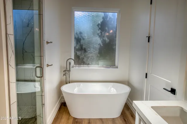 a bathroom with a granite countertop sink mirror and bathtub