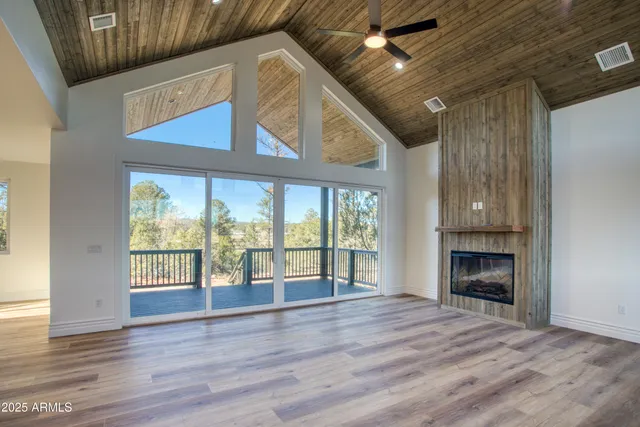 en empty room with wooden floor and windows