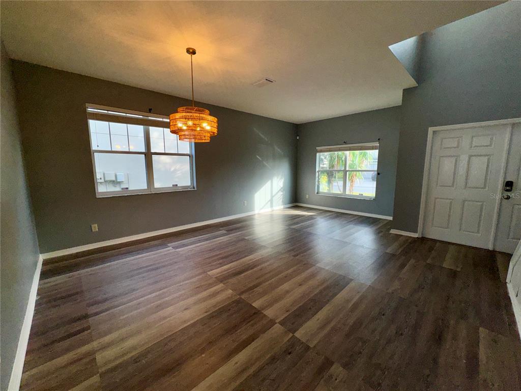 18403 Fish Loop Land O Lakes, FL 34638 - Photo 13 of 64 an empty room with wooden floor and windows