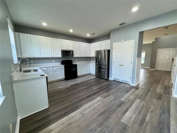 a view of a kitchen counter space wooden floor and staircase