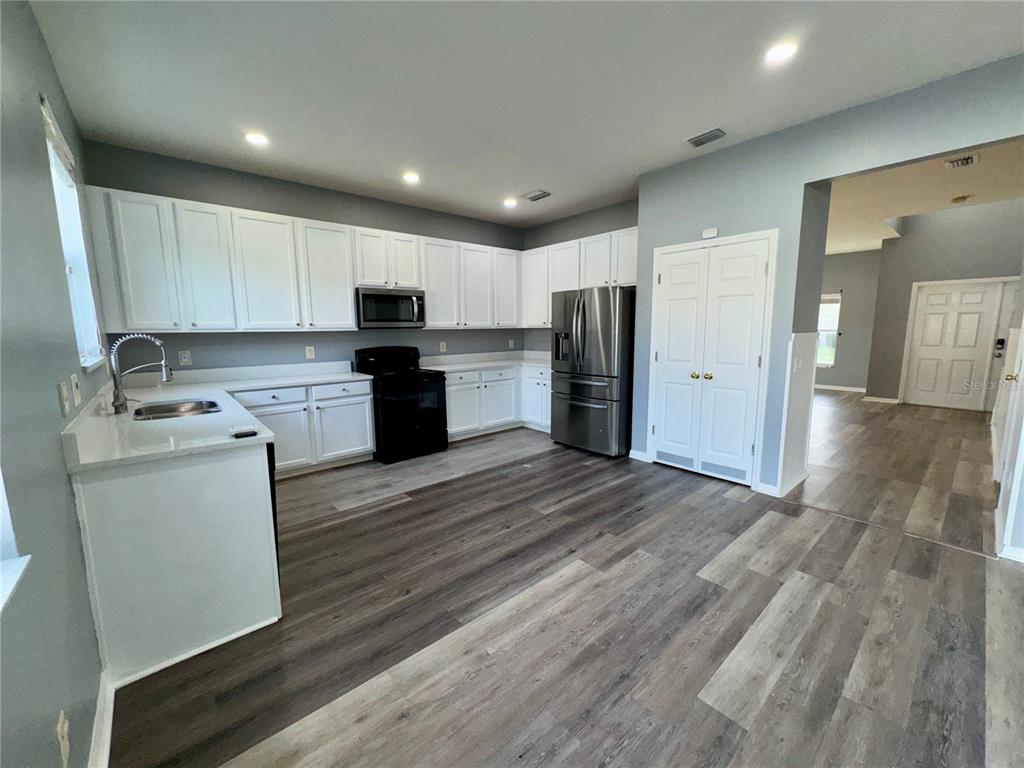 18403 Fish Loop Land O Lakes, FL 34638 - Photo 17 of 64 a kitchen with a refrigerator a stove top oven a sink and cabinets