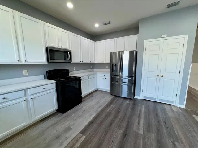 a kitchen with a refrigerator stove and wooden cabinets