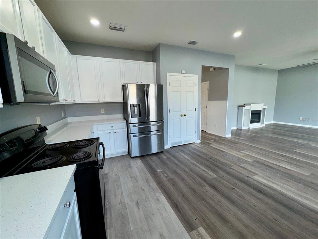 18403 Fish Loop Land O Lakes, FL 34638 - Photo 19 of 64 a kitchen with a refrigerator and a stove top oven
