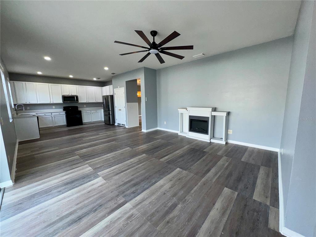 18403 Fish Loop Land O Lakes, FL 34638 - Photo 23 of 64 a view of a livingroom with a fireplace a ceiling fan and wooden floor
