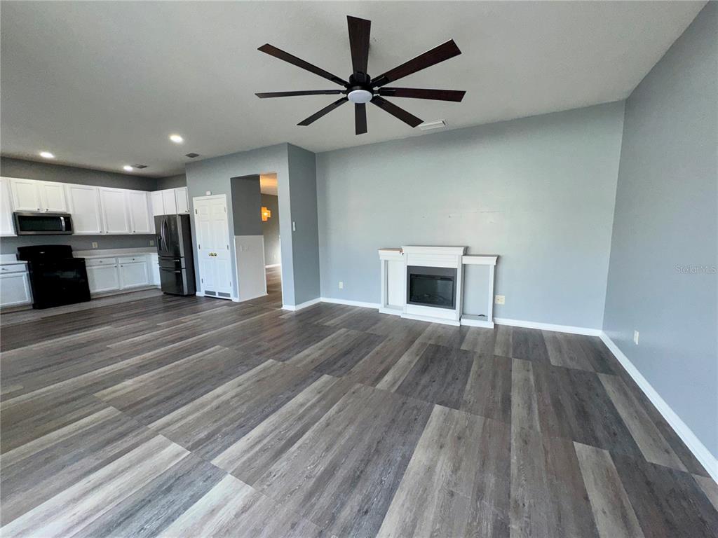 18403 Fish Loop Land O Lakes, FL 34638 - Photo 25 of 64 a view of a livingroom with a fireplace a ceiling fan and wooden floor