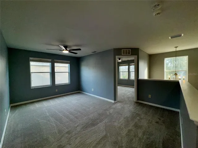 a view of a hallway with closet and a bathroom
