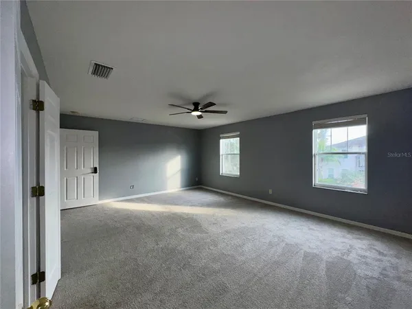 an empty room with fan and a ceiling fan
