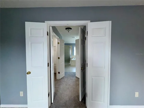 a view of a livingroom with a ceiling fan and refrigerator
