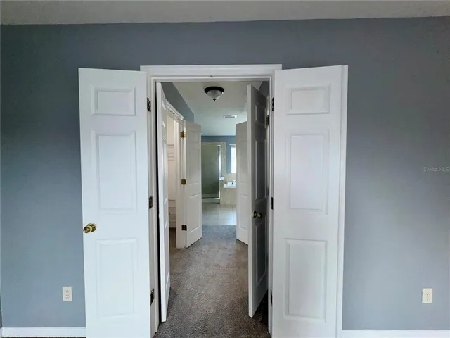 a view of a livingroom with a ceiling fan and refrigerator