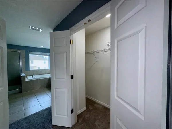 an empty room with closet and fan