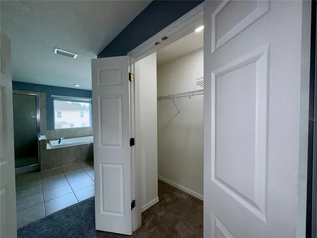 an empty room with closet and fan