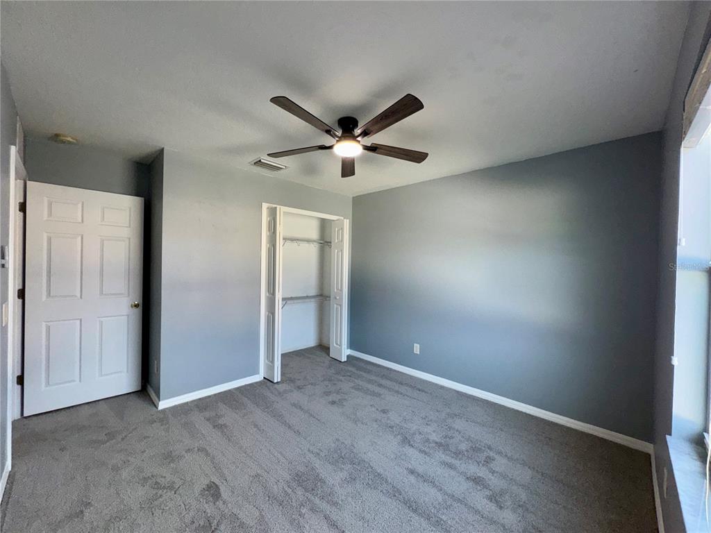 18403 Fish Loop Land O Lakes, FL 34638 - Photo 45 of 64 an empty room with fan and a ceiling fan