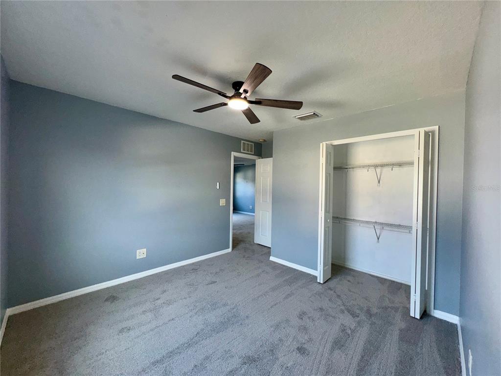 18403 Fish Loop Land O Lakes, FL 34638 - Photo 46 of 64 a view of a livingroom with a ceiling fan and refrigerator