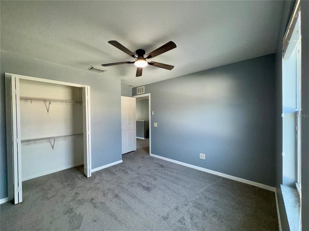 18403 Fish Loop Land O Lakes, FL 34638 - Photo 47 of 64 an empty room with closet and a ceiling fan