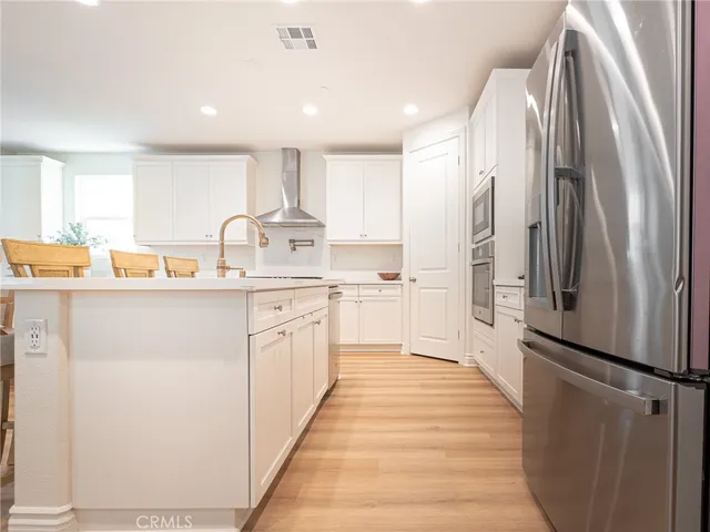a kitchen with stainless steel appliances a refrigerator sink and white cabinets