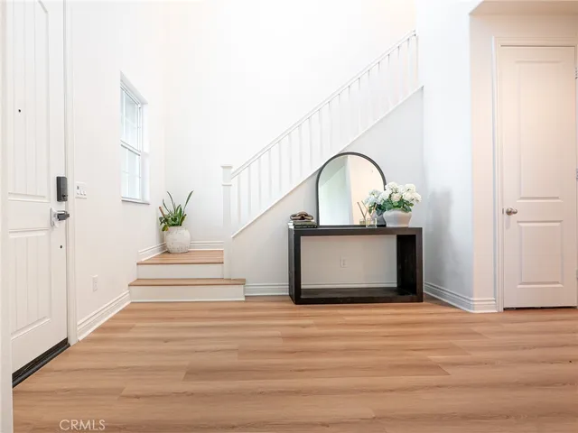 a view of a hallway with wooden floor and a potted plant