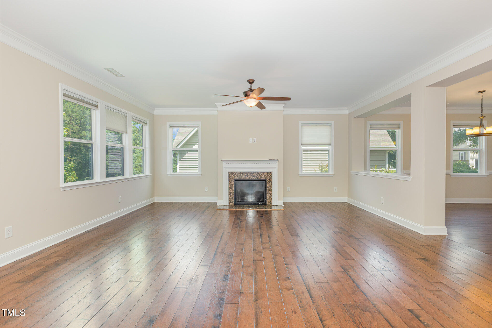 1304 Barnford Mill Road Wake Forest, NC 27587 - Photo 7 of 40 a view of an empty room with wooden floor fireplace and a window