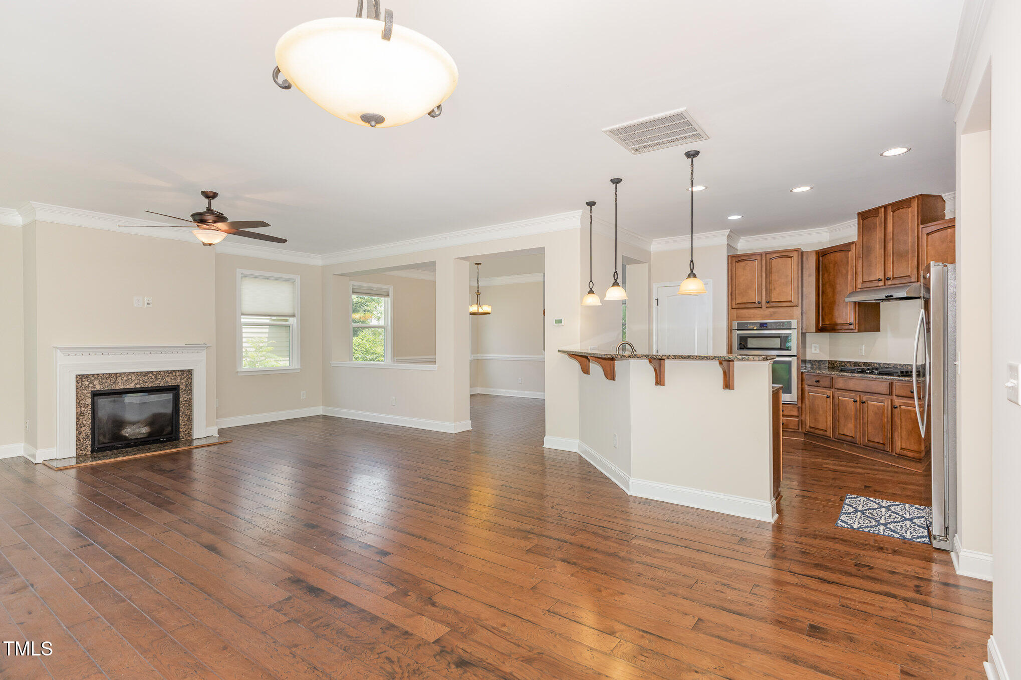 1304 Barnford Mill Road Wake Forest, NC 27587 - Photo 8 of 40 a view of an empty room with wooden floor and a kitchen
