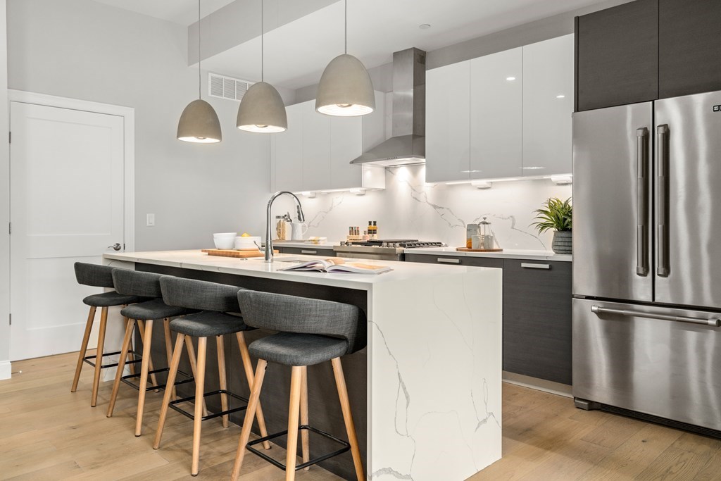 a kitchen with granite countertop a table chairs stove and refrigerator