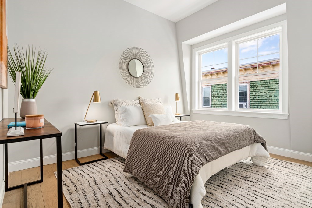54 Pleasant Street, Unit 5 Boston, MA 02125 - Photo 4 of 23 a bedroom with a large bed and a window