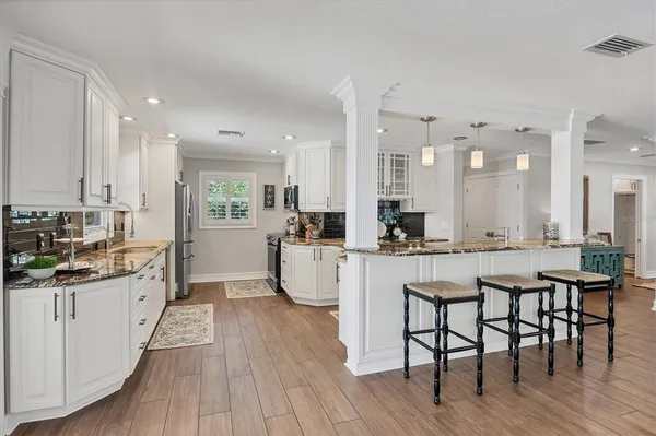 a kitchen with granite countertop a stove a sink and a wooden cabinets
