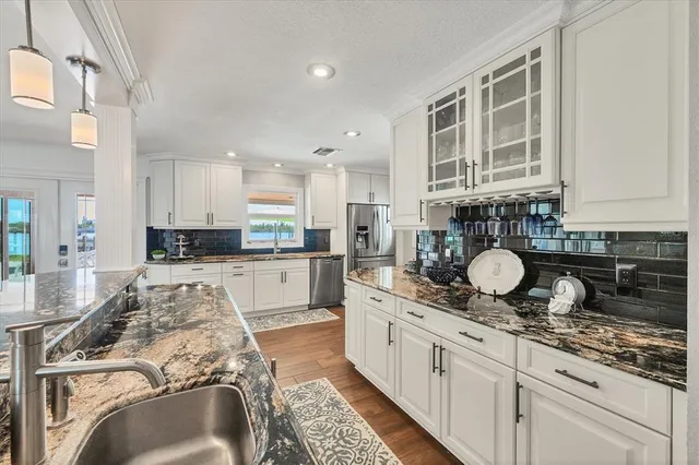 a kitchen with stainless steel appliances kitchen island granite countertop a stove a sink and a refrigerator
