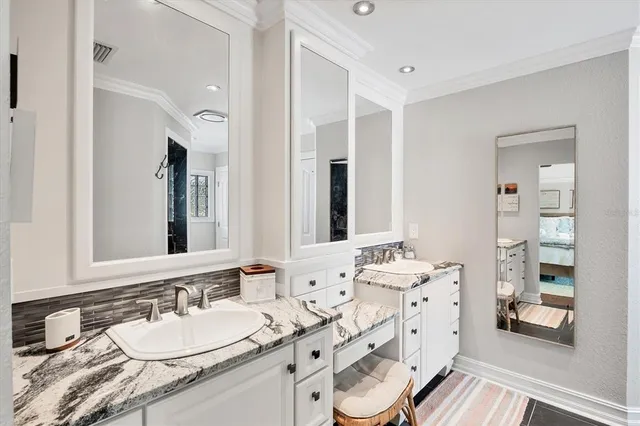 a bedroom with a bed a chandelier and a couch