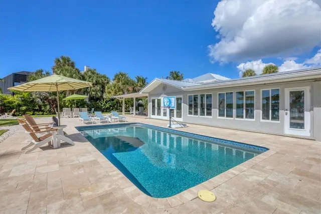 a view of a house with swimming pool and sitting area