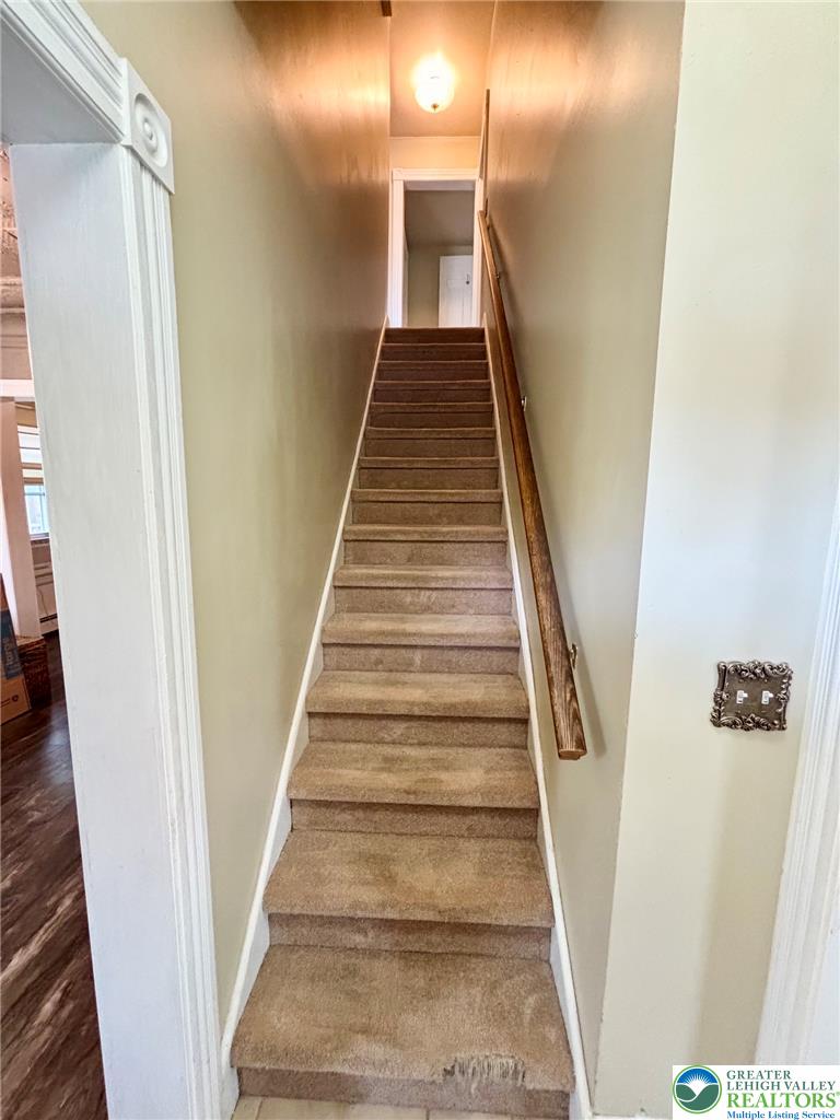 7241 Decatur Street New Tripoli, PA 18066 - Photo 15 of 36 Ascend to comfort with this inviting carpeted stairway, featuring a classic wood railing.