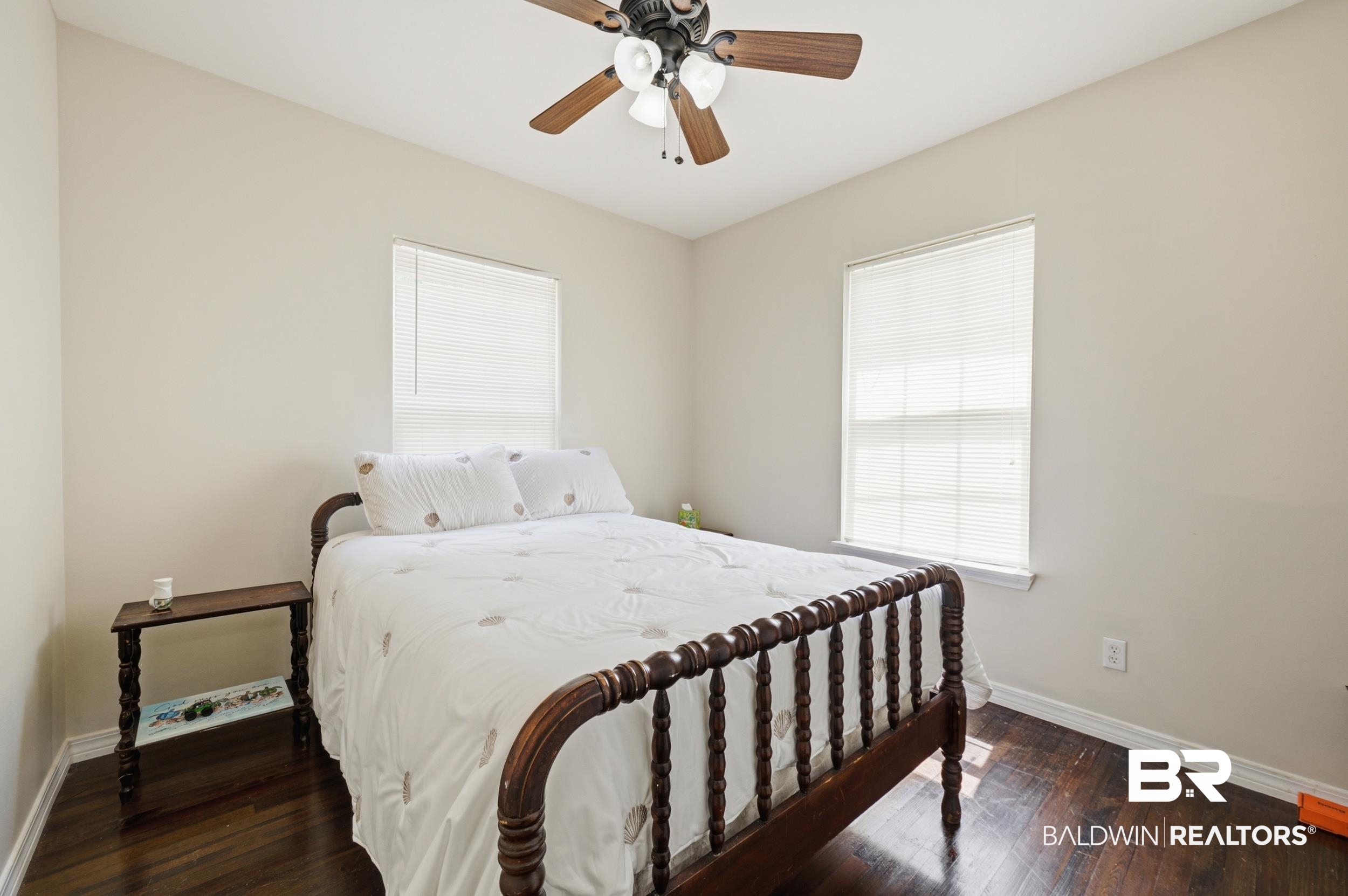 42080 Bayou Road Bay Minette, AL 36507 - Photo 25 of 43 Interior room featuring two windows with horizontal blinds, dark wood-finish flooring, and a ceiling fan with integrated lighting