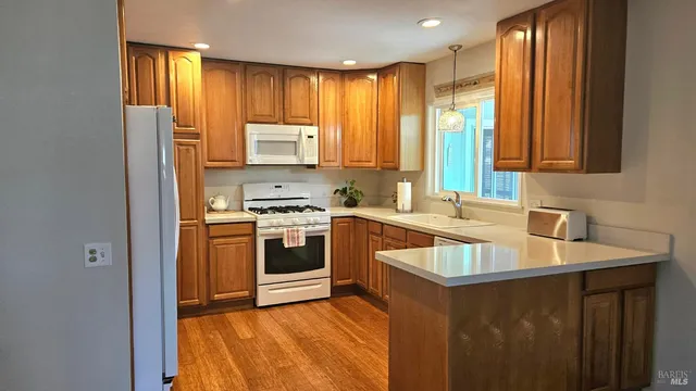 a kitchen with a sink stove top oven and refrigerator