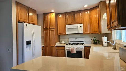 a kitchen with stainless steel appliances granite countertop a refrigerator stove and sink