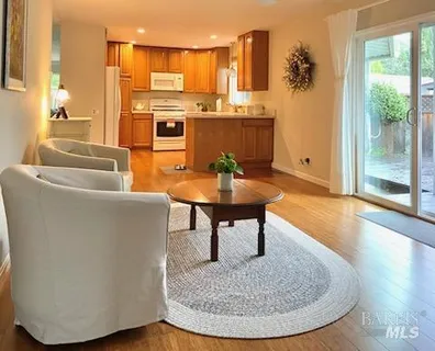 a living room with furniture a large window and kitchen view