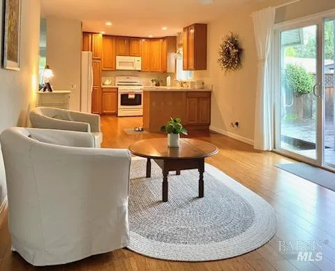 a living room with furniture a large window and kitchen view