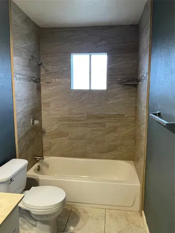 a bathroom with a toilet bathtub and shower