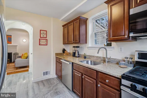 a kitchen with stainless steel appliances granite countertop a sink stove and cabinets