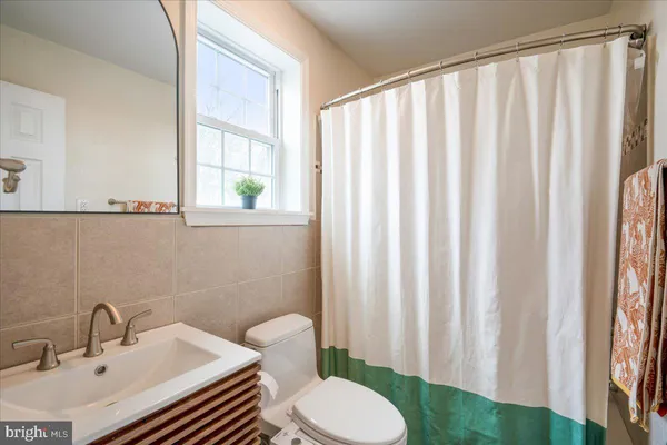 a bathroom with a sink a toilet and a mirror
