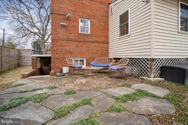 a view of backyard with wooden fence and large trees
