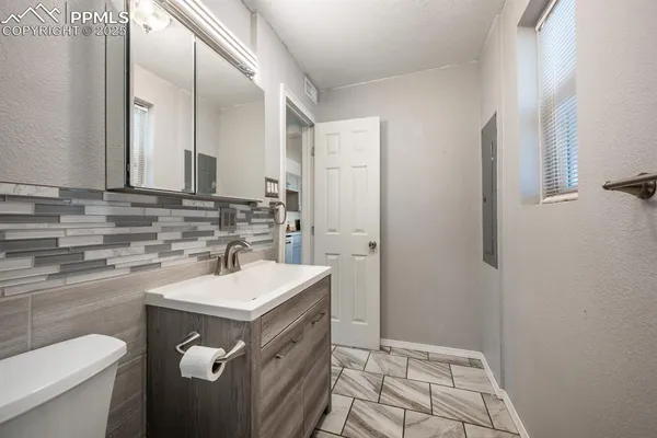 a bathroom with a sink a toilet and a mirror