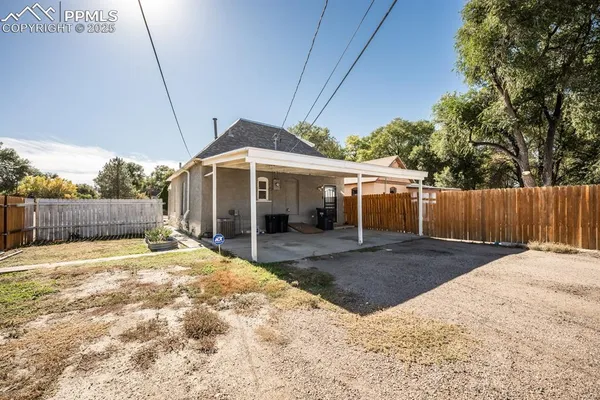 a view of a house with a yard and wooden fence