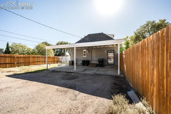 a view of a large house with wooden fence
