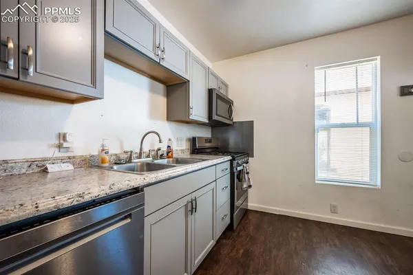 a view of a kitchen with sink and dishwasher with wooden floor